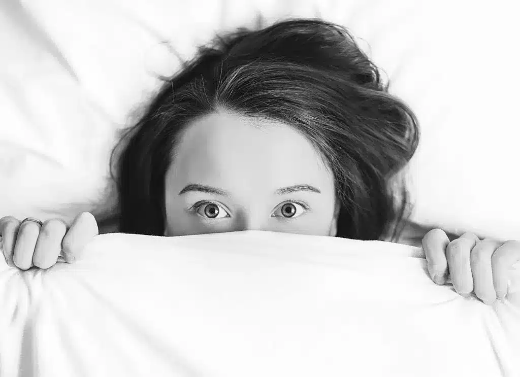 Women hiding under the covers because of cyber threats